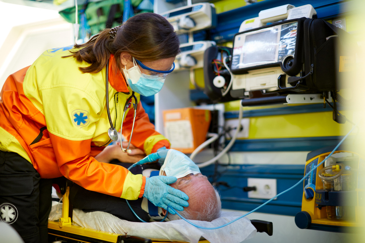 EMT and her patient inside an ambulance wearing protective masks