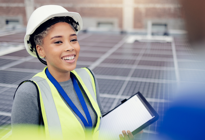 worker standing next to solar panels