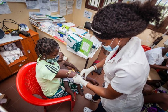 A mother receiving a blood test during a clinical visit.