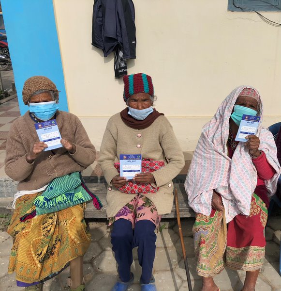 senior citizens showing vaccine cards after receiving covid vaccine in dang district