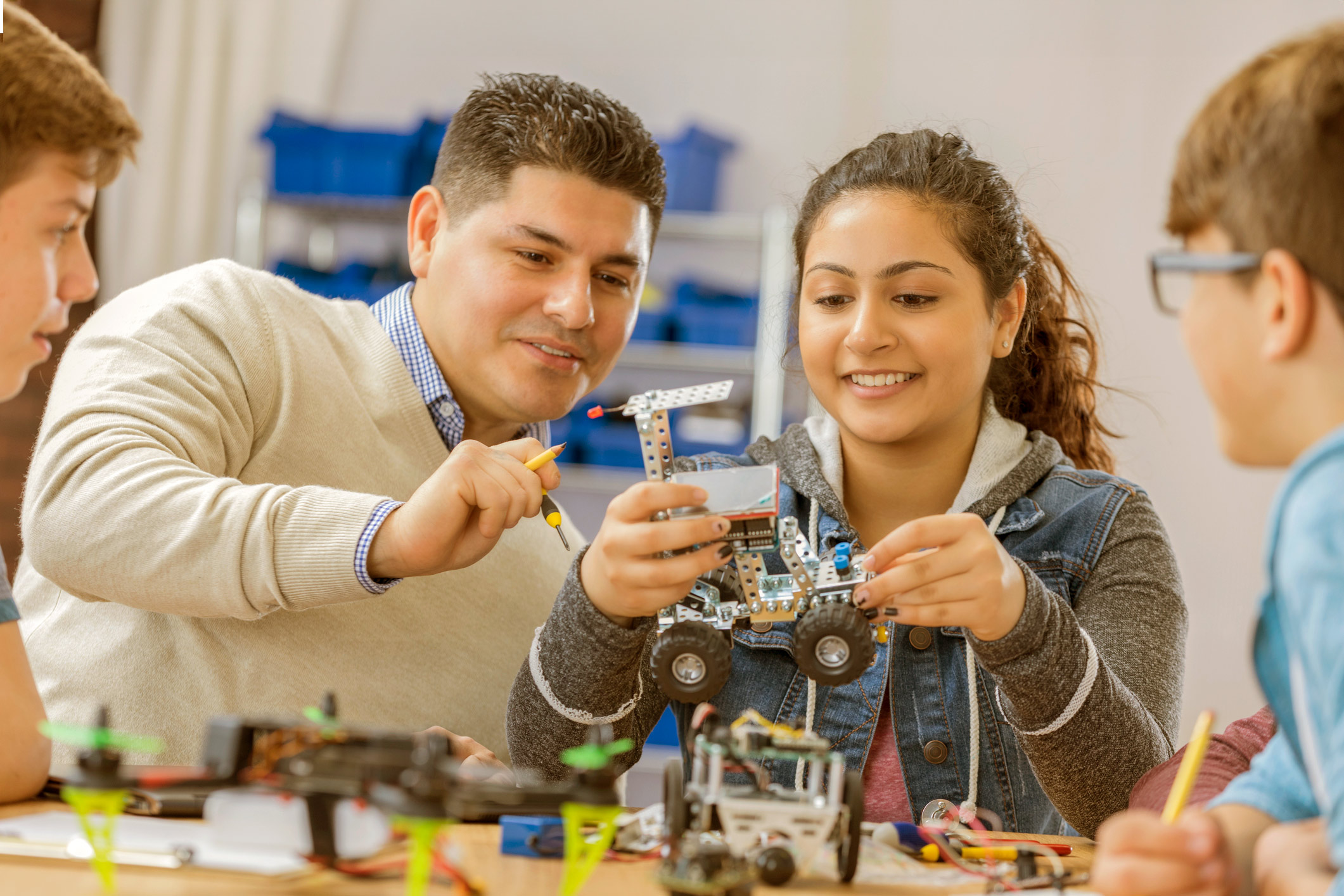 Teacher with smiling students working on science project