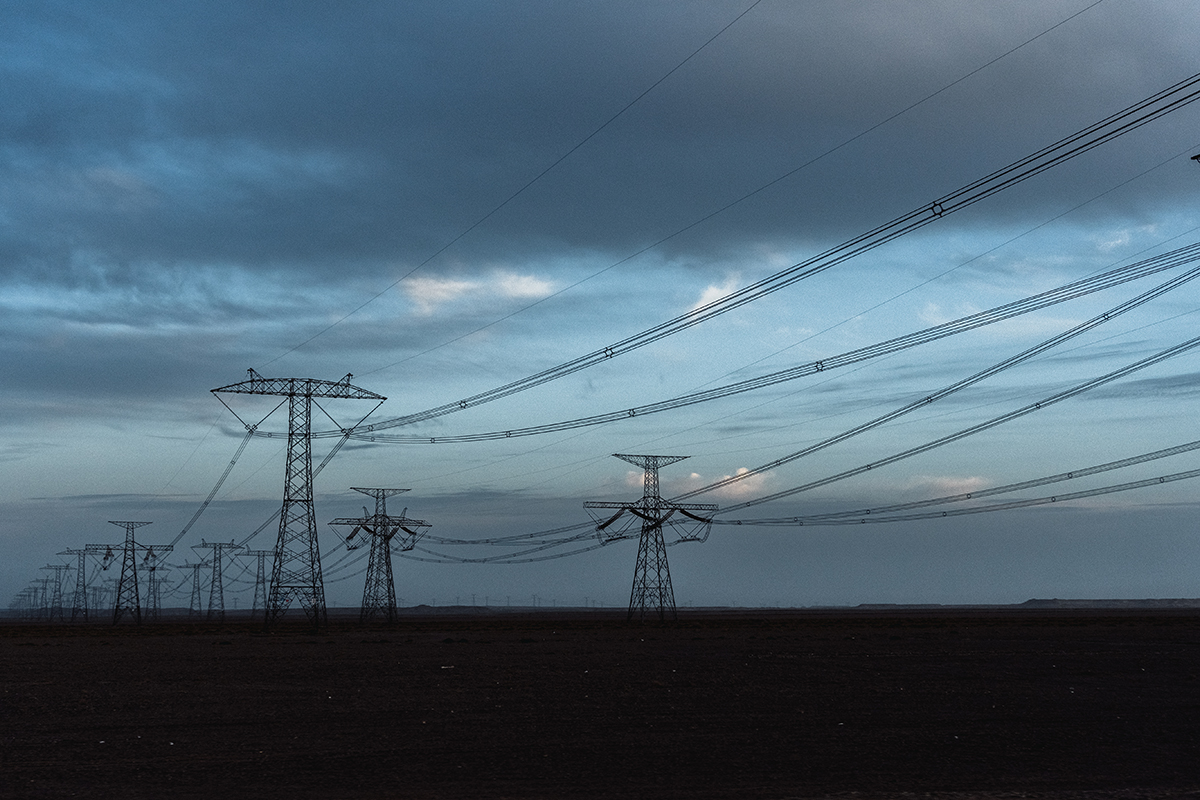 Powerlines running into the distance under a cloudy sky