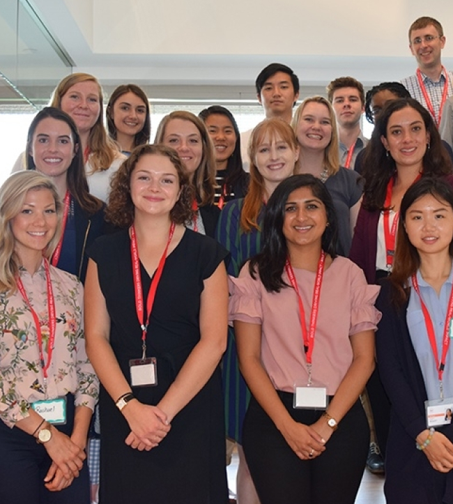 A group of Abt Global interns smiling for a photo in the lobby of our Rockville, Maryland office.