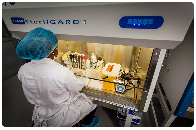 Lab technician sitting in front of a testing equipment