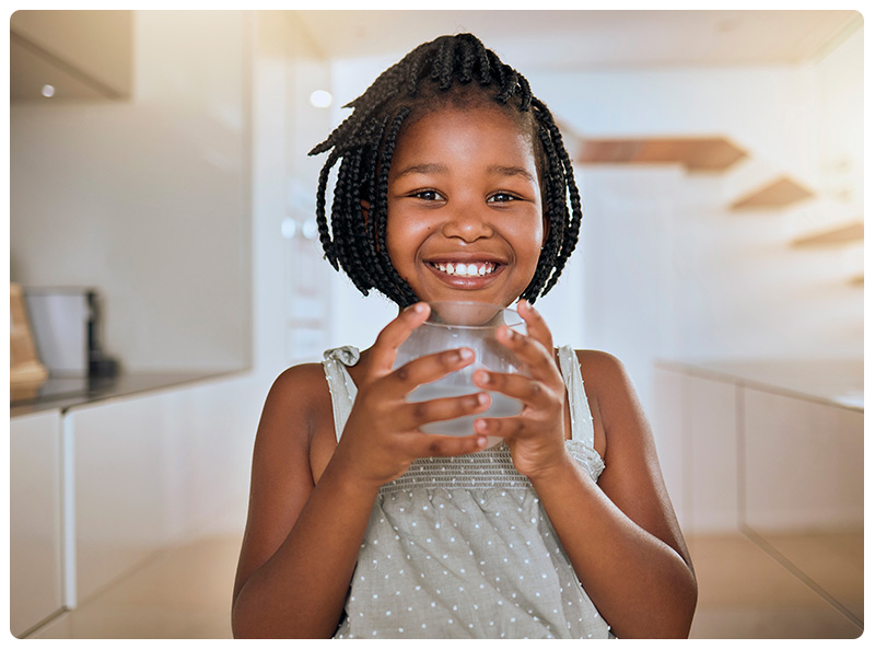 Young girl holding a glass of water