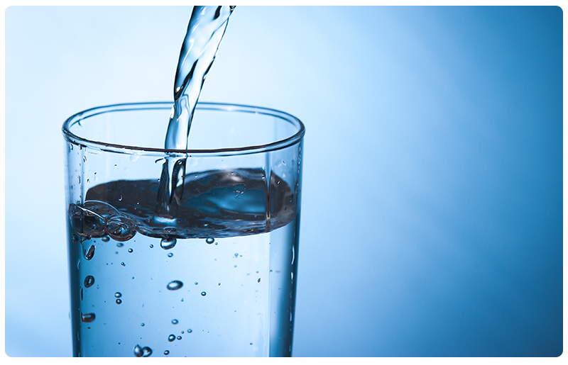 Water pouring into a glass cup
