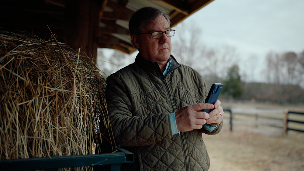 chris long on his farm looking at his phone