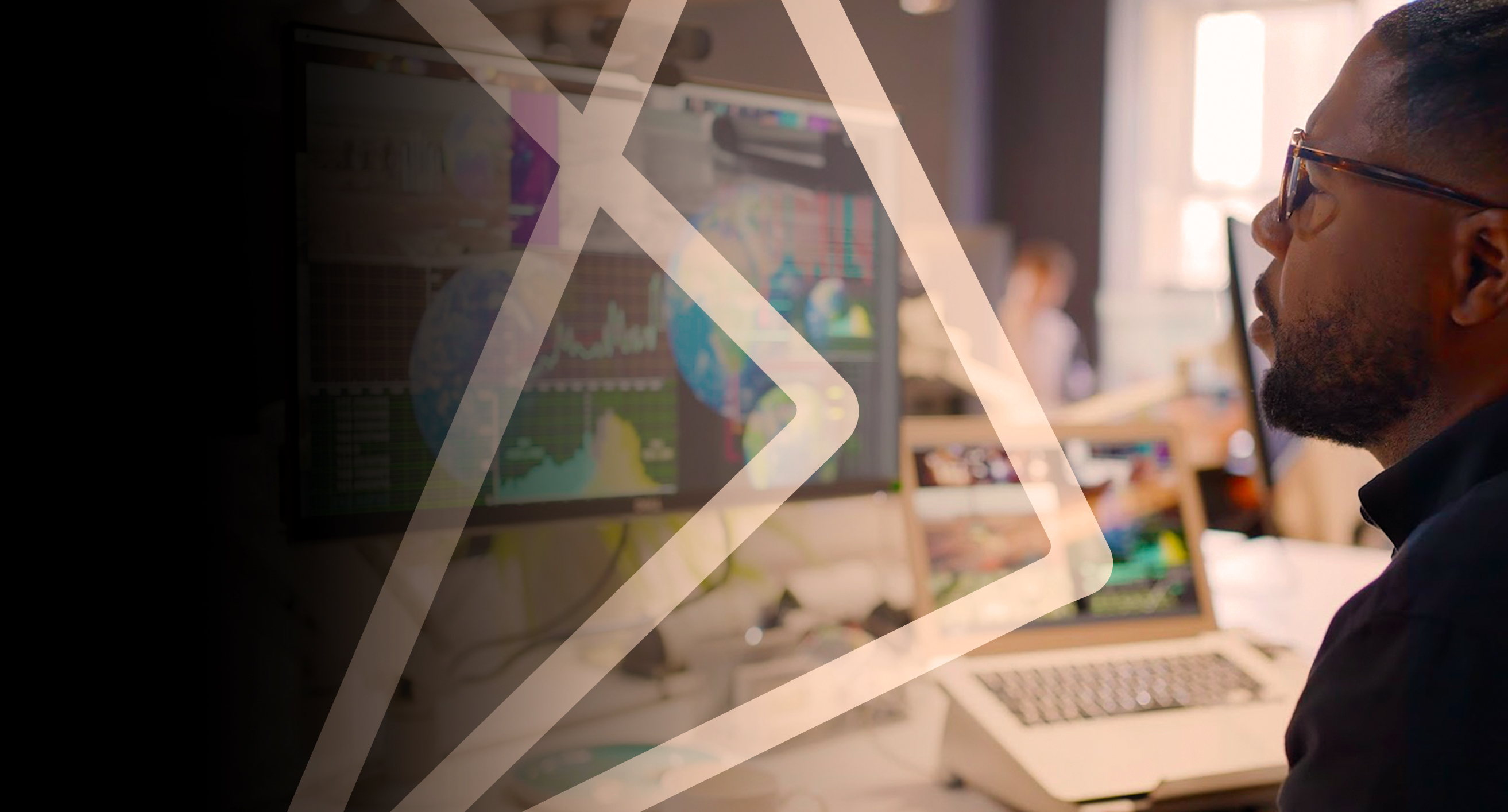 Man looking at a computer monitor showing images of globes and charts of data.