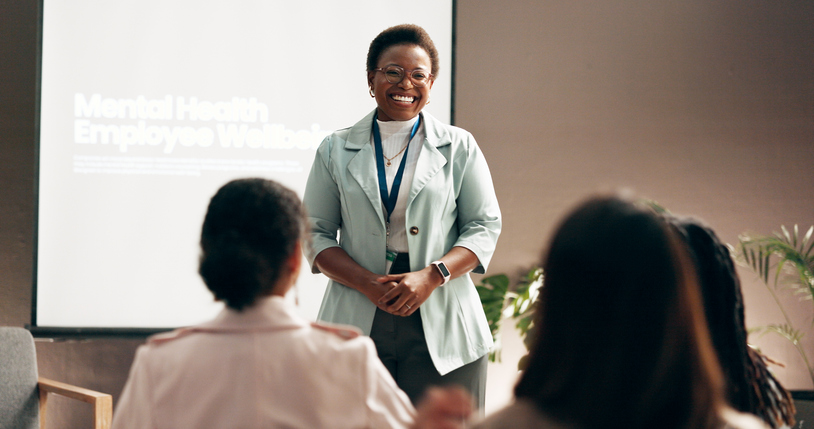 smiling teacher in front of a classroom