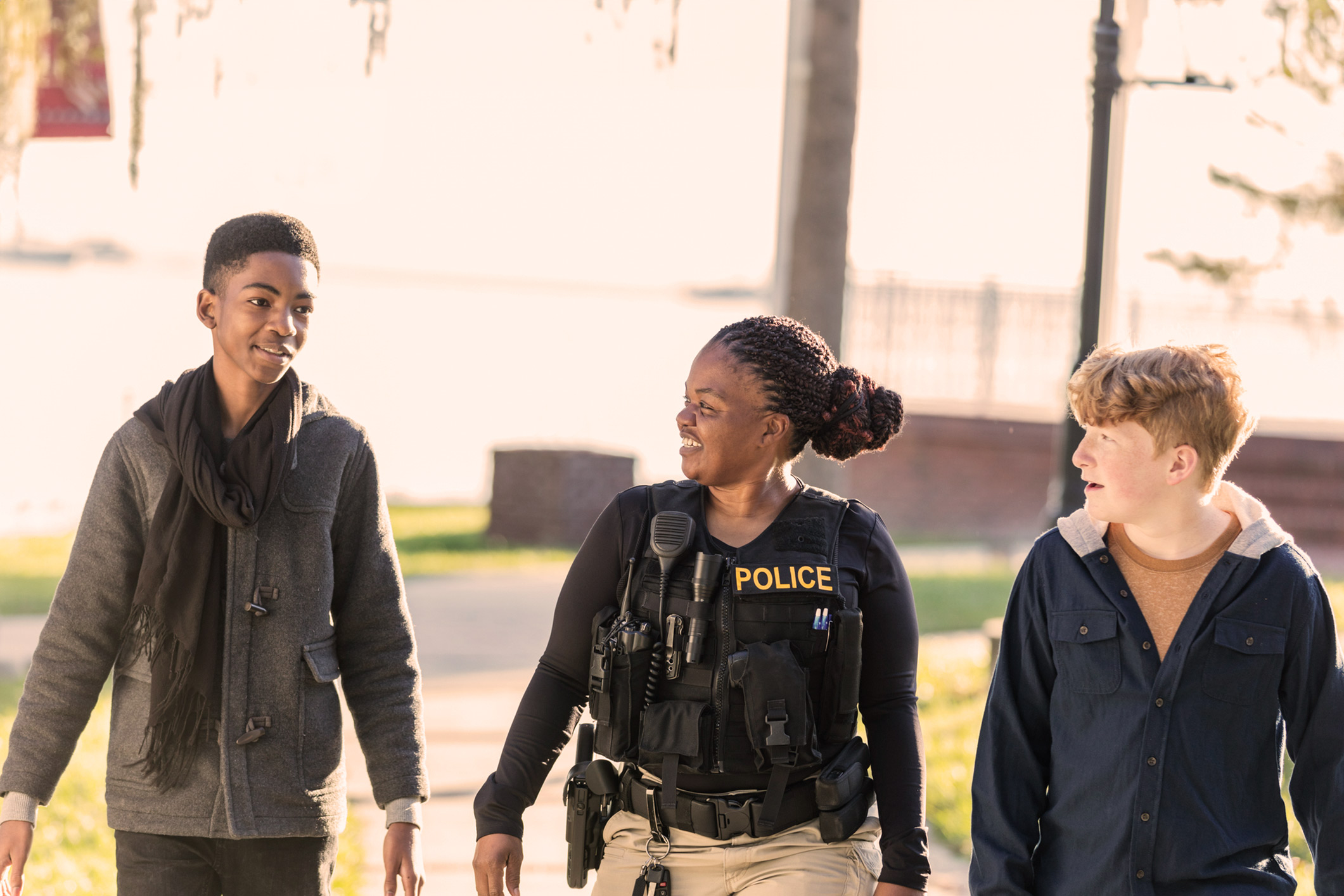 police woman talking and walking with two teenagers