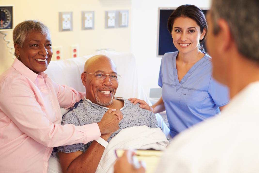 doctor talking to a smiling patient and his family