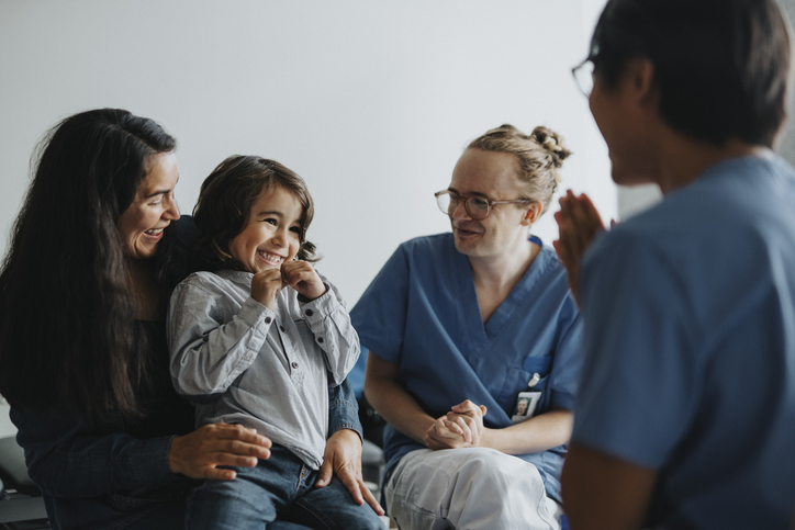 doctors talking with smiling child and her mother