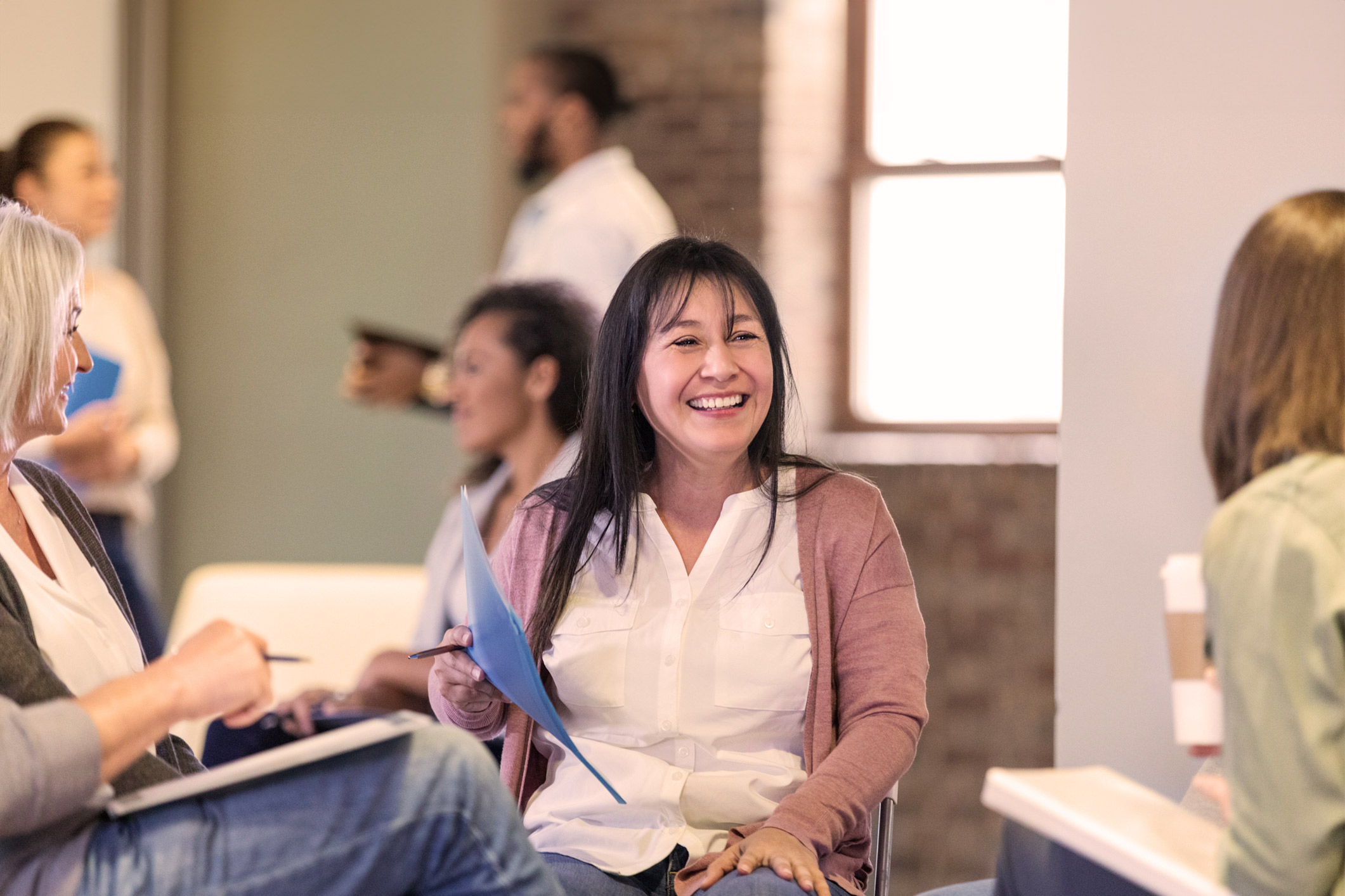 women talking and smiling in a circle of chairs