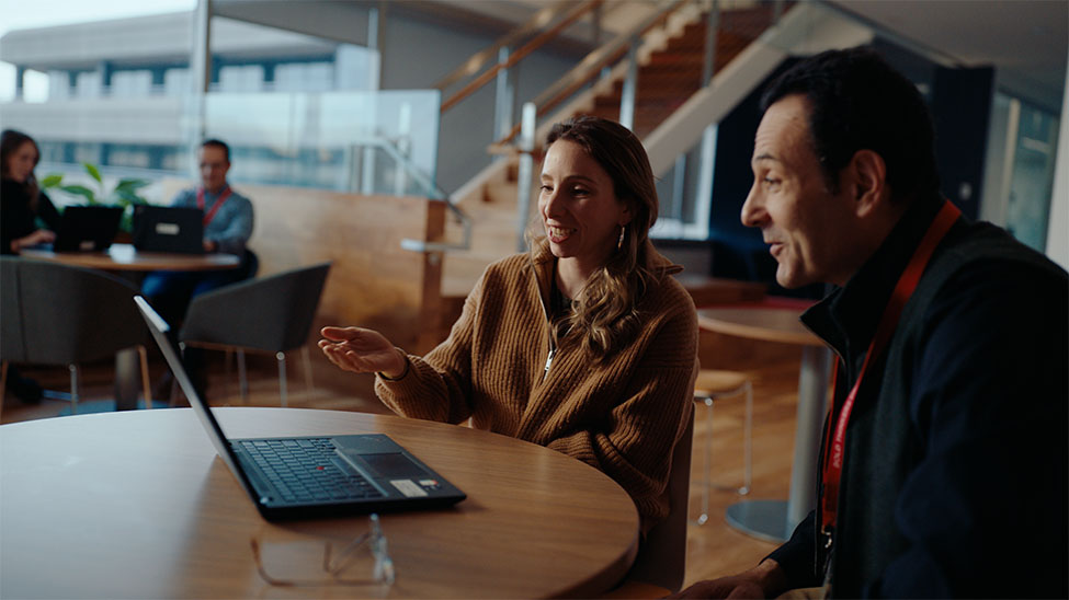 two colleagues sitting at a laptop talking