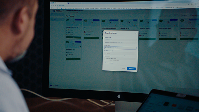 man looking at large computer screen
