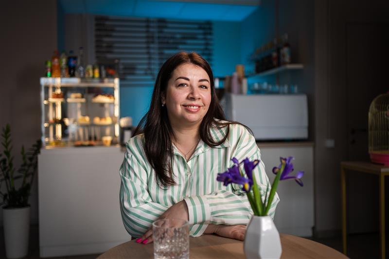 Ukrainian woman and entrepreneur Farida smiling and talking in a cafe