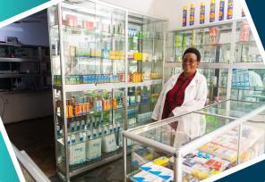 smiling pharmacist standing behind a counter in africa 