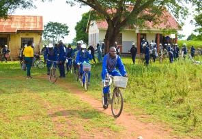 malaria control workers biking from a village in uganda