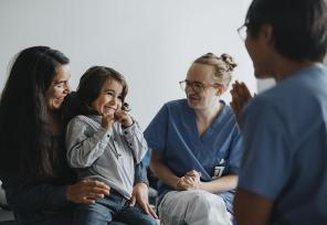Doctors talking to a mother and smilling child