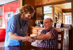 medical professional making home visit to care for elderly man