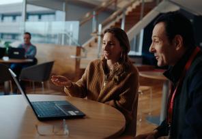 two colleagues talking over a laptop