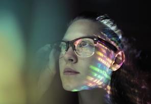 artistic photo of a computer screen reflected in a woman's glasses