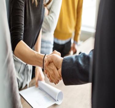 people shaking hands over a contract