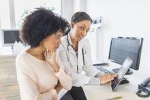 doctor talking to a patient while they both look at a tablet