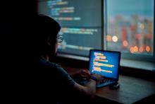 artistic photo of a person looking at a glowing computer screen