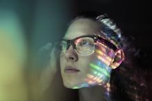 artistic photo of a computer screen reflected in a woman's glasses