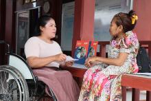 a woman in a wheelchair talking to another woman