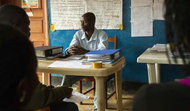 instructor sitting in front of a classroom in DRC