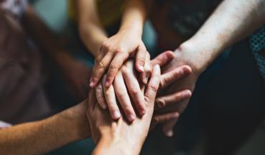 artistic view of hands on top of other hands