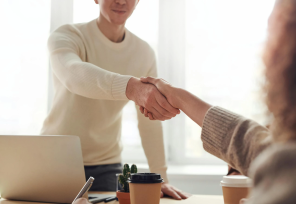 A close up image of two people engaged in a handshake.