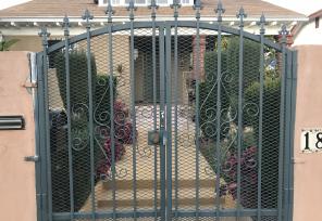 Closed metal gates in front of a home