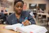 woman writing in a textbook