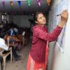 Woman in Nepal writing on a chart in a classroom