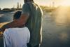 father walking with his arm around his son