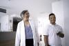 Female senior doctor welcoming / greeting special needs boy at hospital