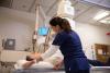 Female patient lying down ready for an C-arm xray and radiologist getting ready the machine