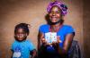 A mother holding medications with her child