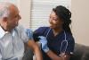 smiling doctor giving a patient a shot