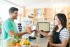man handing a grocery clerk his credit card
