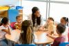 teacher talking happily to young students