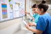 Two Nurses Examining medication on Bulletin Board