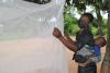 woman drying mosquito netting in africa