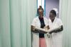 two Haitian medical professionals smiling and talking