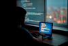 artistic photo of a person looking at a glowing computer screen