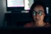 artistic photo of a computer screen reflected in a woman's glasses 