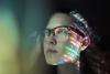 artistic photo of a computer screen reflected in a woman's glasses